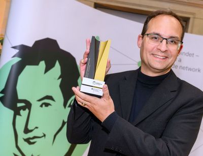 Professor Daniel Kráľ holding a Humboldt Foundation trophy.