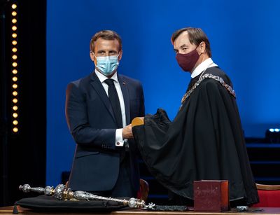 Emmanuel Macron bekommt das Ehrendiplom feierlich überreicht.
